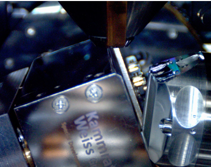 Fig 1. Measurement setup in the scanning electron microscope, viewed using the SEM chamberscope. The heating stage is tilted 70° with respect to the electron beam towards the Symmetry S2 EBSD camera. Left: Setup at ambient conditions. Right: Setup at ~850 °C, showing the significant infra-red radiation.